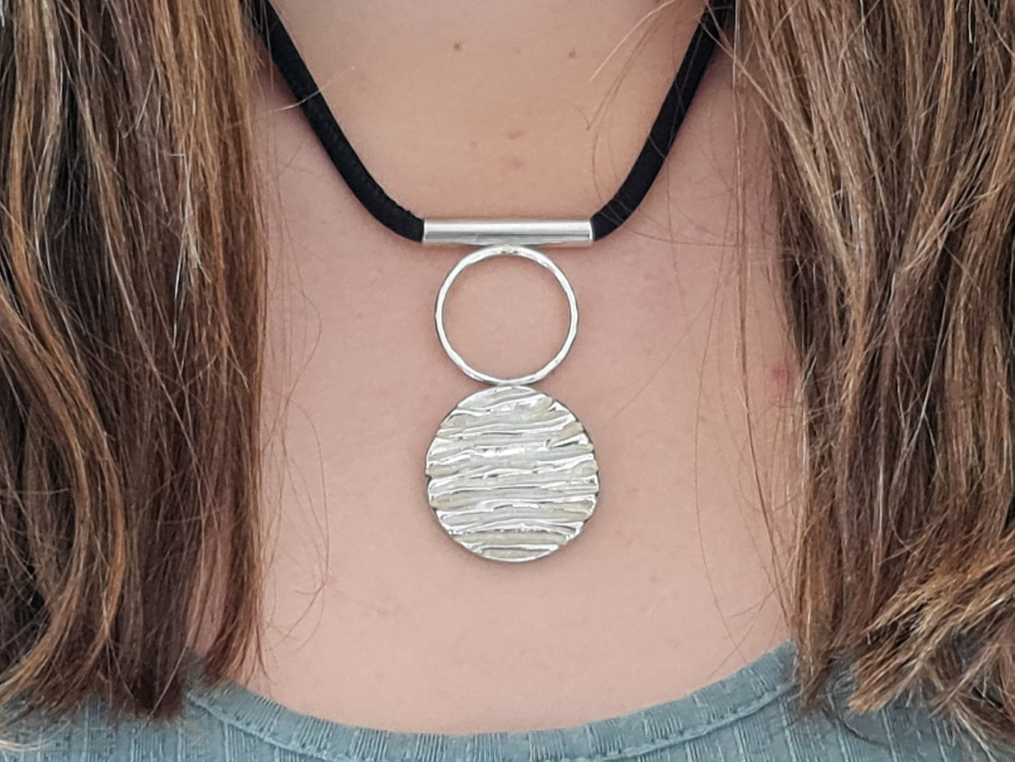 Cinderhill wood pendant necklace with black silk chain on female neck