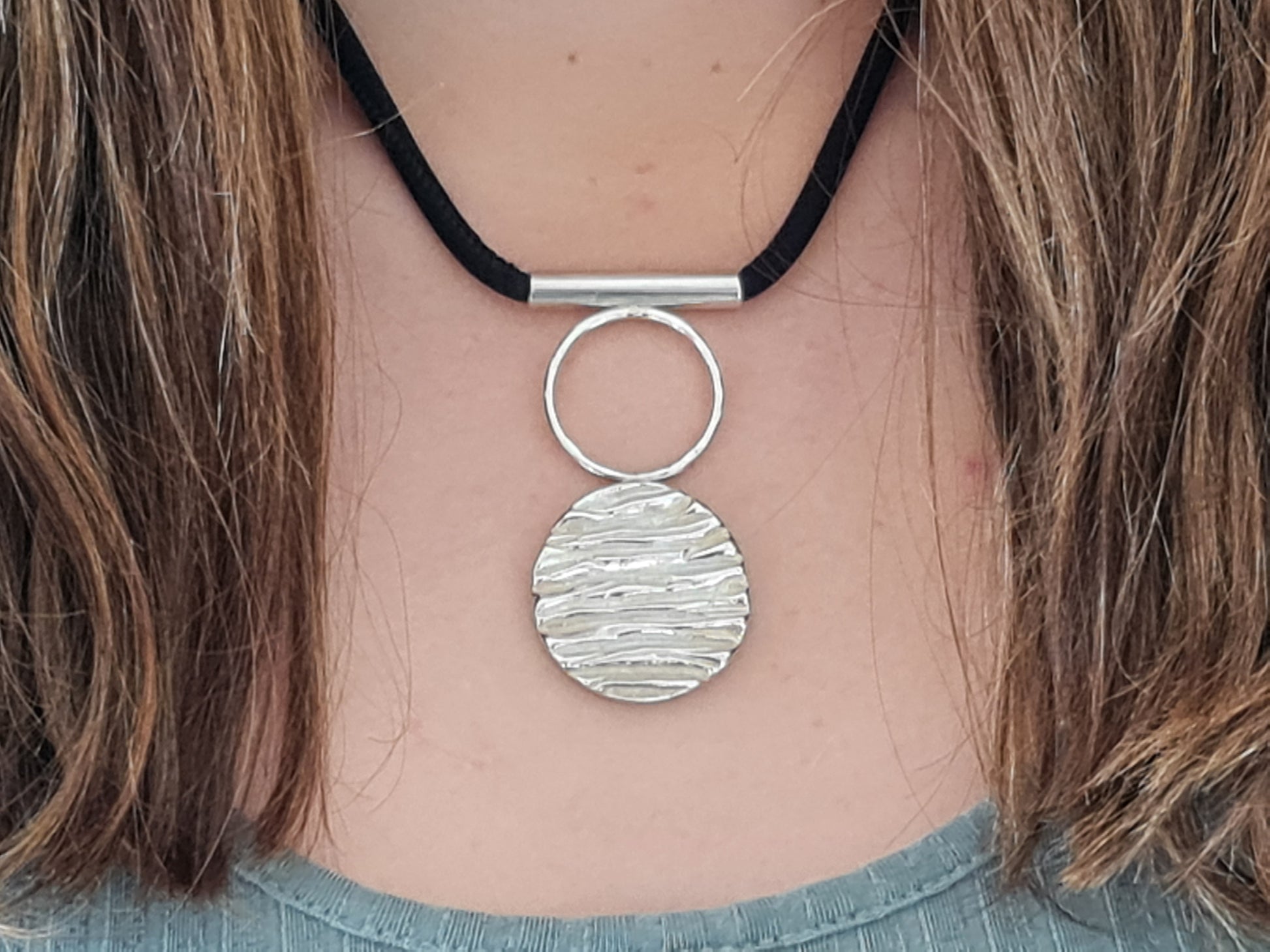 Cinderhill wood pendant necklace with black silk chain on female neck