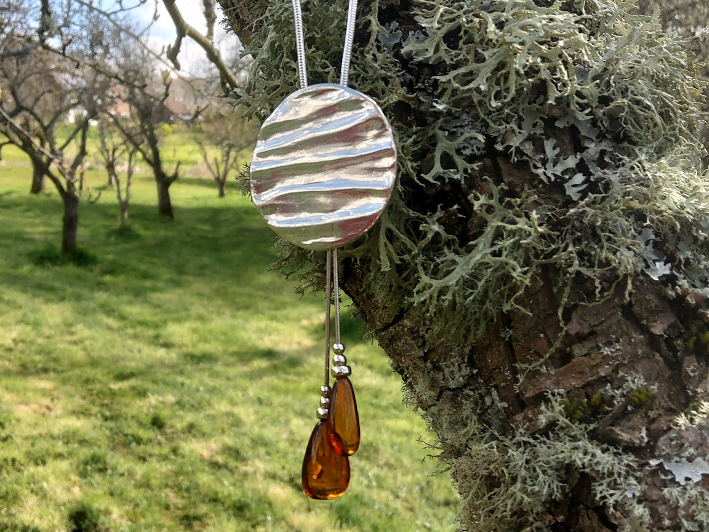 Textured sterling silver handmade pendant with amber beads
