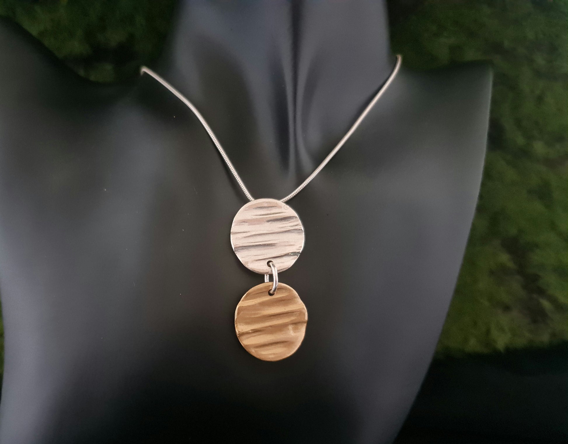 Amsbury wood duo pendant silver and bronze necklace shown on a black faux neck