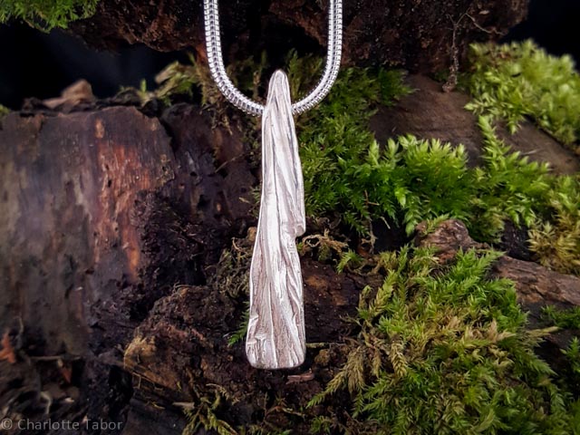 Sterling silver broken bark Quarry Wood Pendant on a snake chain with a moss background
